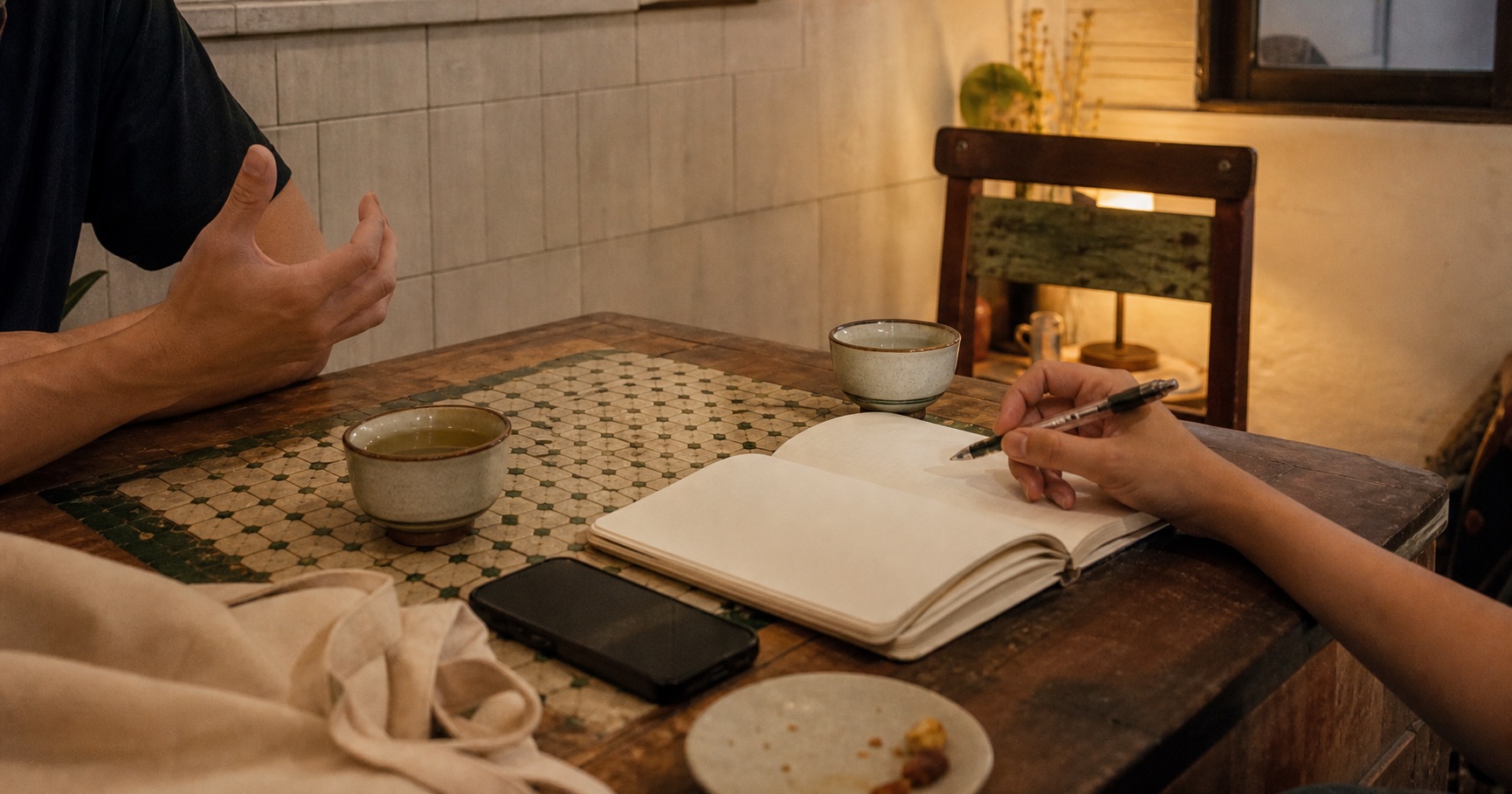 桌邊筆記、茶杯與合作對話的氣氛影像