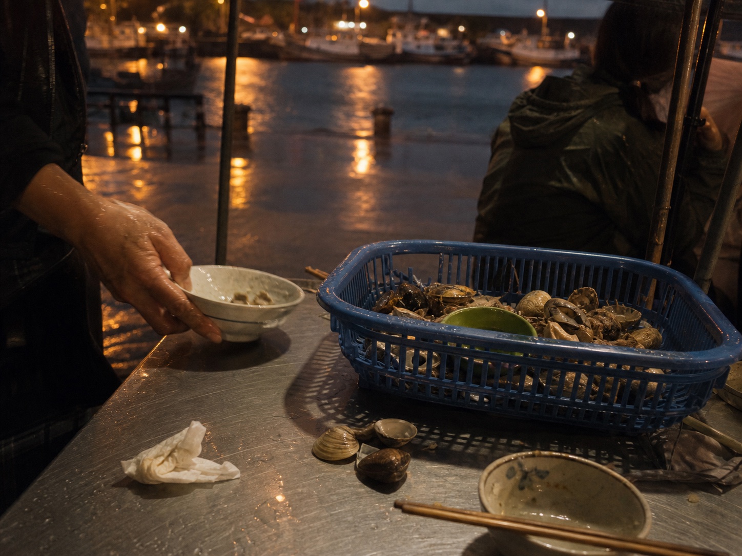 港邊晚餐、濕地反光與藍色魚籃的氣氛影像